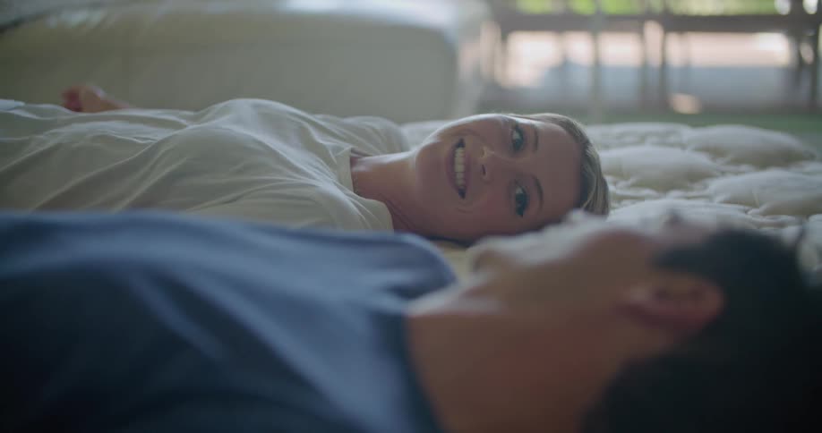 A man and woman are testing a bed together