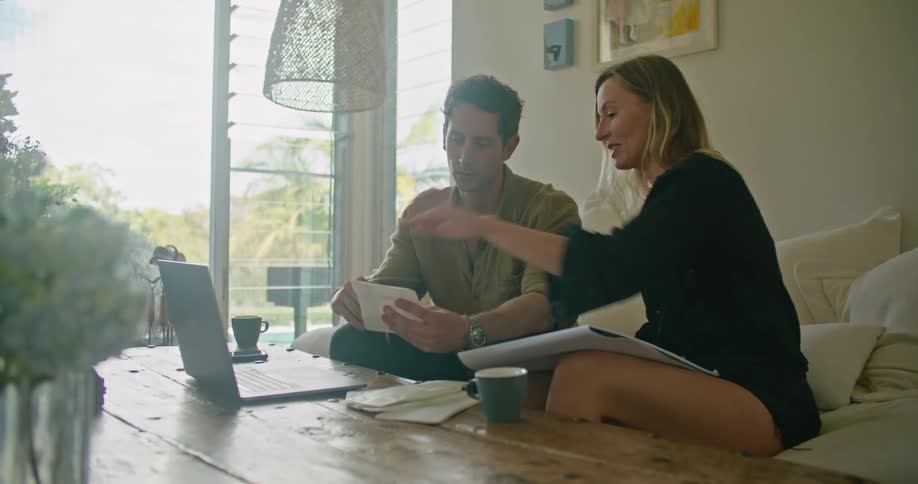 A sketch artist listens to a man as he shows her something on small pieces of paper