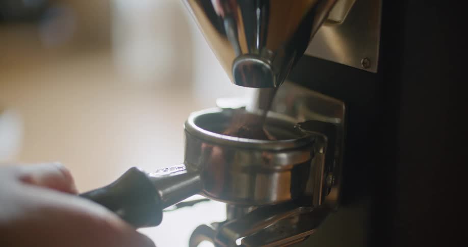 Man filling the filter of an espresso machine with ground coffee