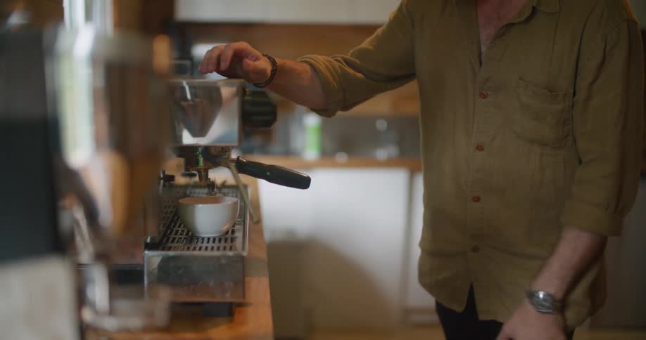 A man is preparing a cup of espresso on a large machine