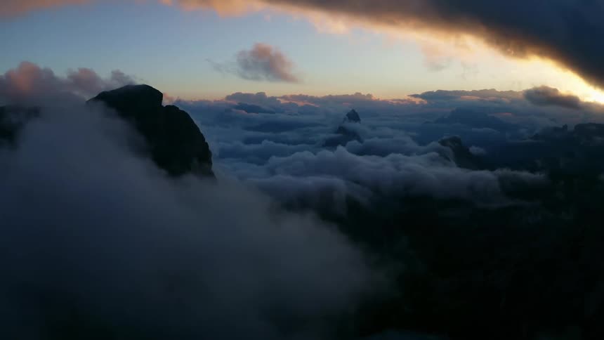 Mountain peaks high in the sky above the clouds