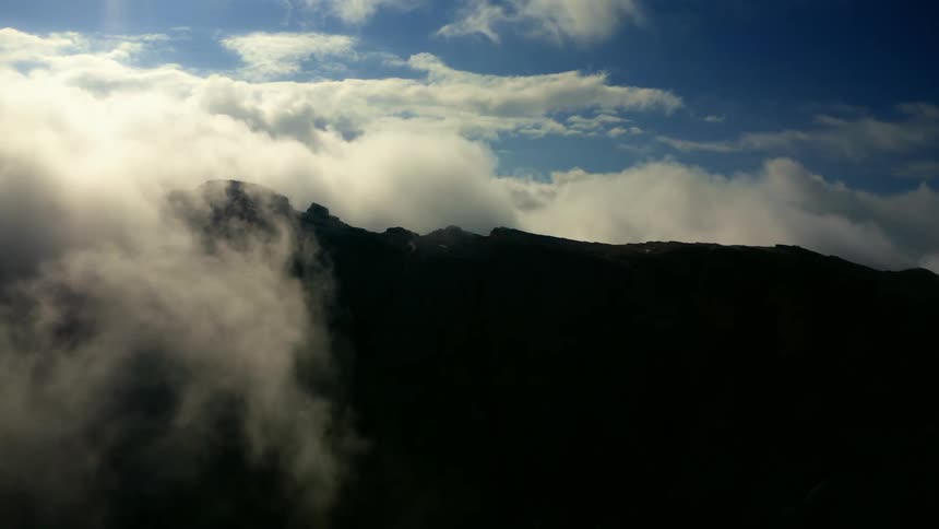 An aerial view of hills with clouds over them