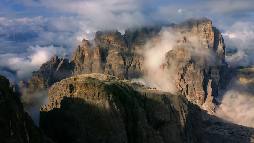 A rock mountain range shrouded in clouds and fog