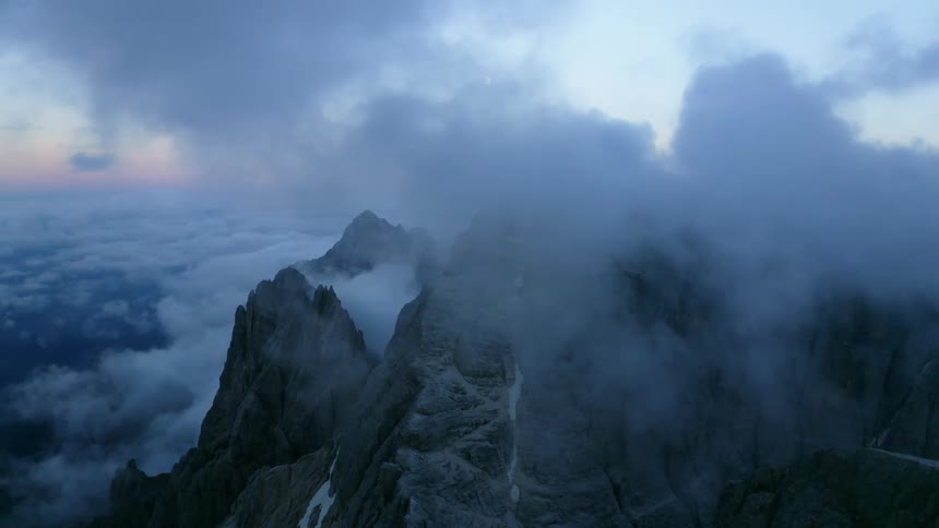 Mountain peaks high in the sky among the clouds