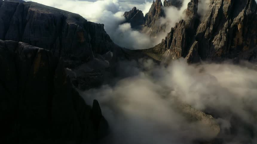 Fog shrouds valley and parts of jagged peaks