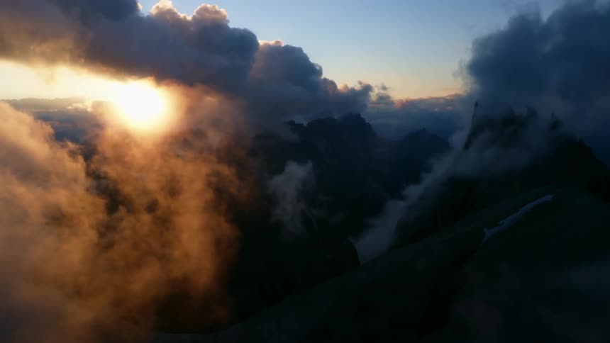 Heavy clouds and fog move over a mountain range