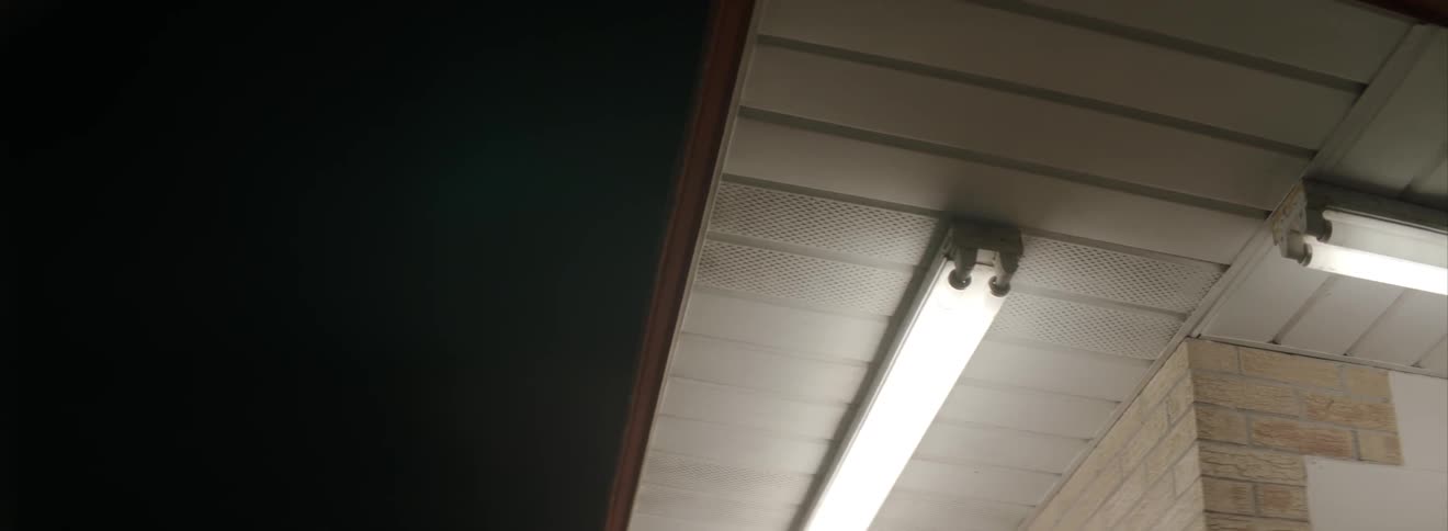 Close up of a florescent light on a building at night