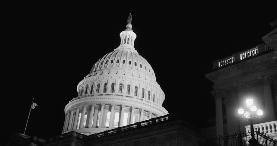 The dome of the capitol building at night with the lights on