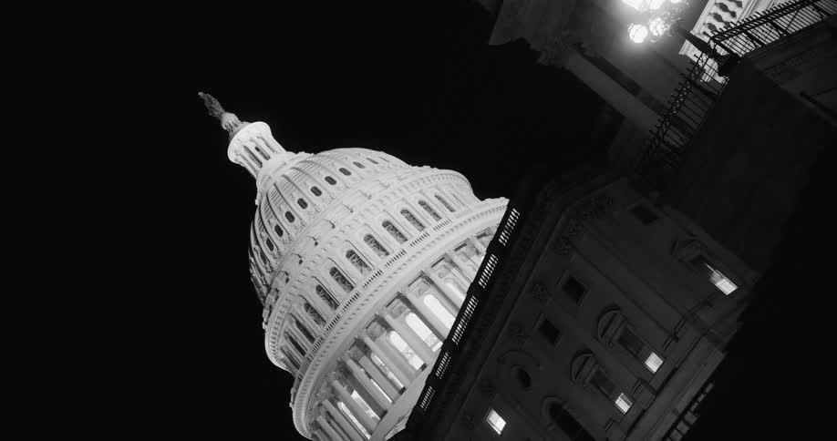 Capitol building dome glows white against night sky