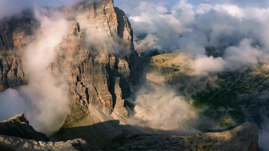 Aerial view of mountains covering the jagged slopes and cliffs of a mountain in the morning