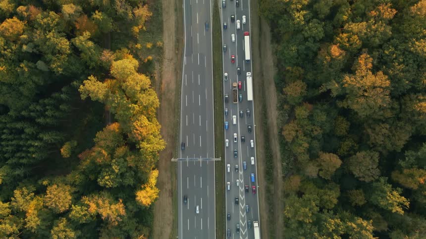 Aerial view of traffic on a busy highway and trees along the side of the road in fall colors
