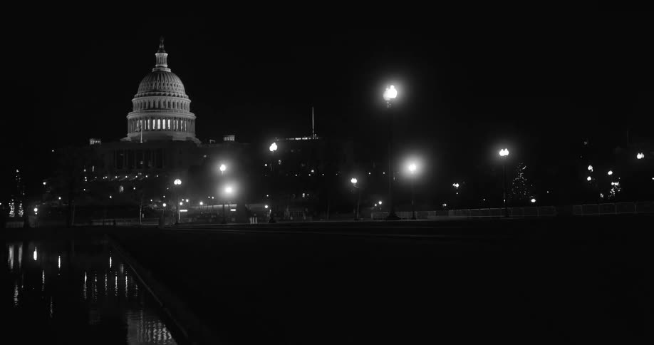 The white dome of the capitol building against a night sky