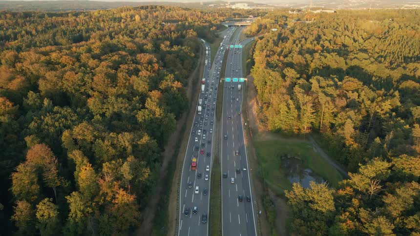 Aerial view of a busy highway and trees along the side of the road in fall colors
