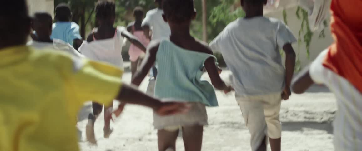 Children run down a street in a village