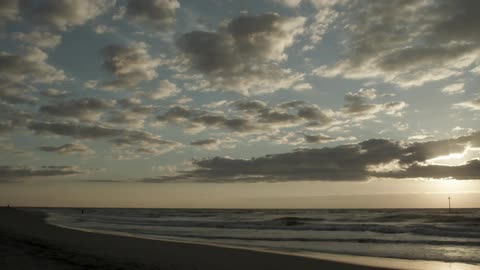 In the distance a person walks in the shallow water