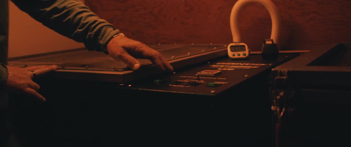 A man reaches over and touches the button