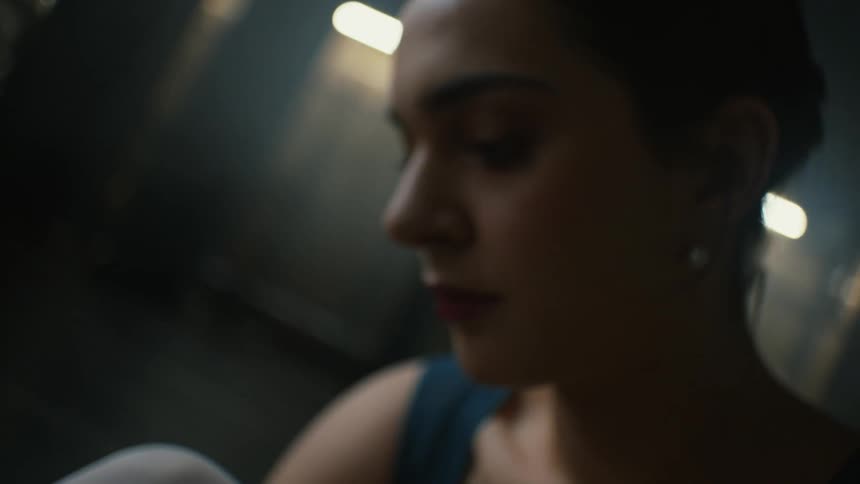 A ballerina looks down as she ties her shoes