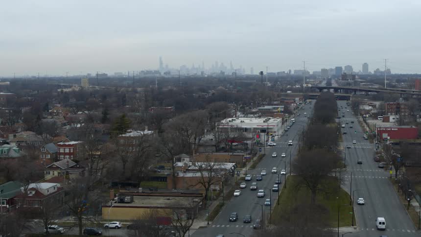 Aerial view of traffic in an urban area and a city skyline on the horizon