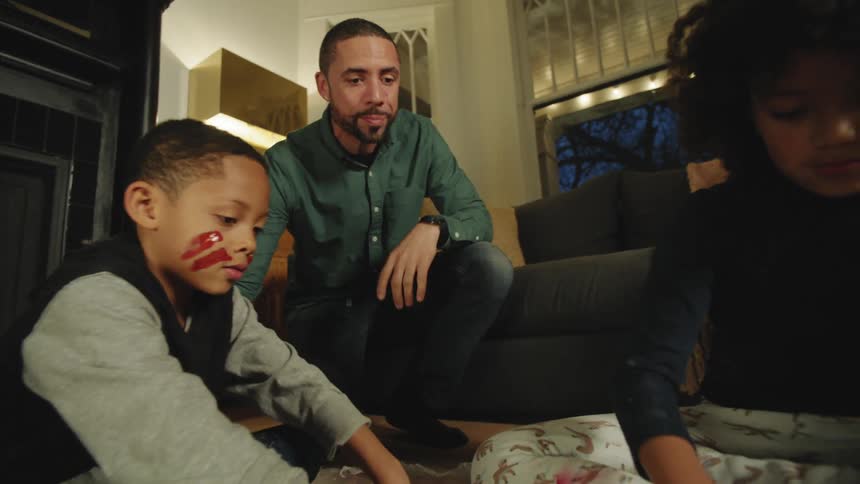 A father and children painting in a room