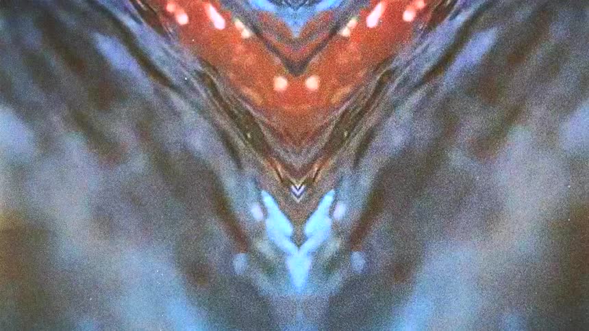 Reflected mirrored image of water flowing under random light flares caught on vintage film