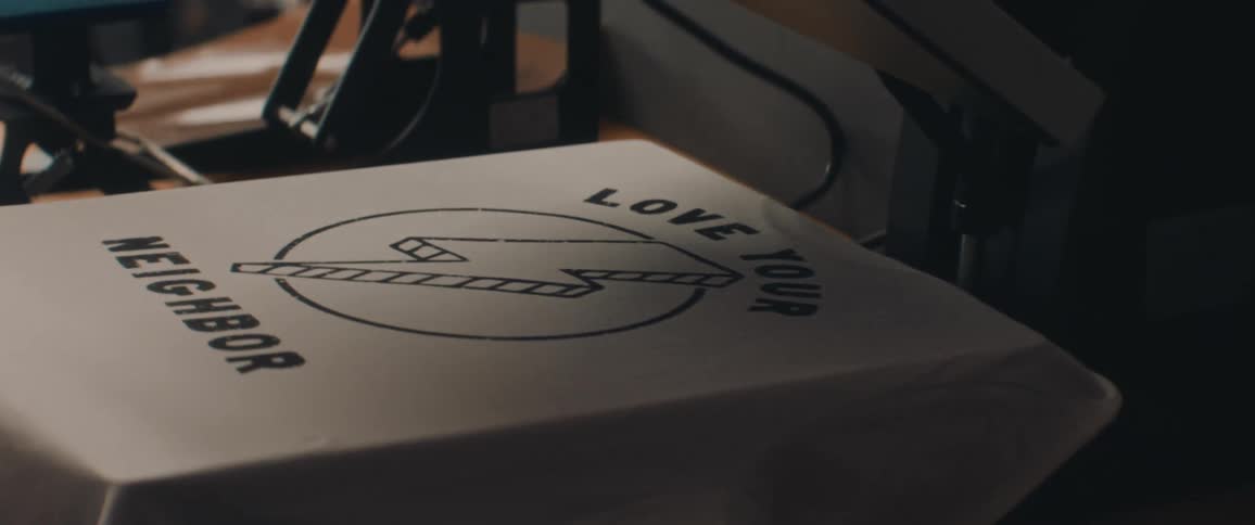 A man uses the machine to put a graphic on the shirt