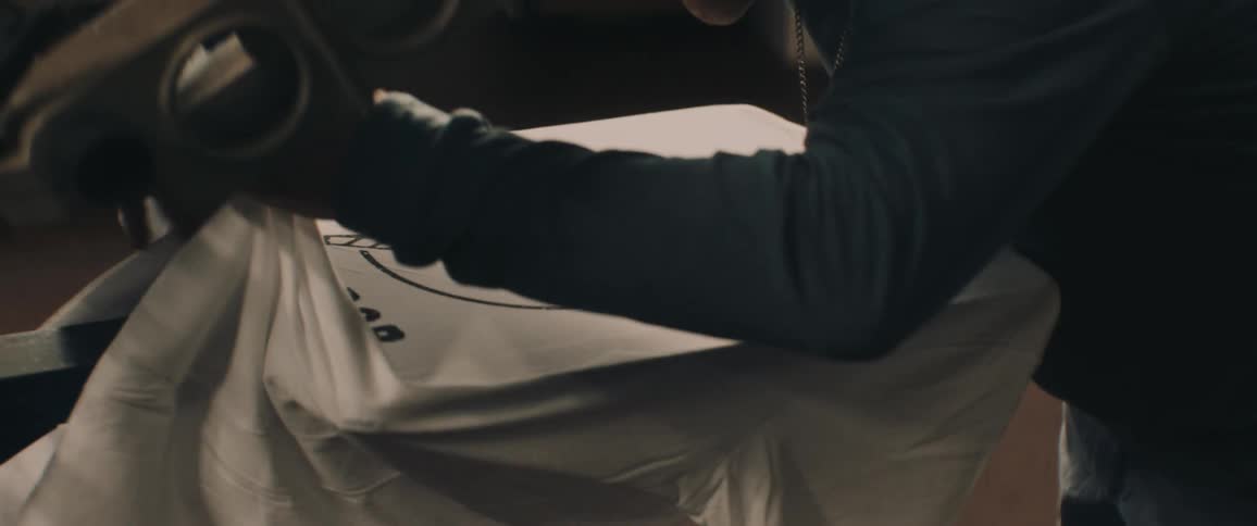 Person adjusts t shirt on silk screen press