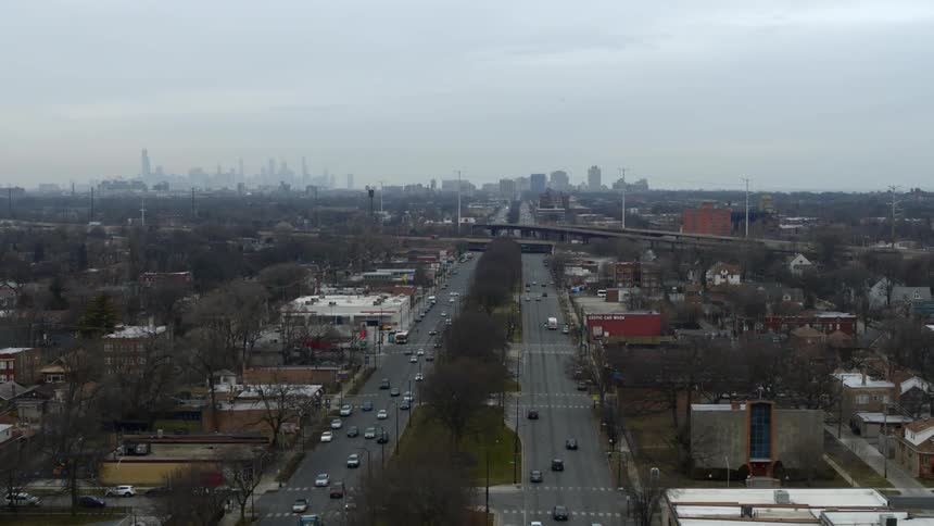 Traffic passes to and from foggy city on divided highway