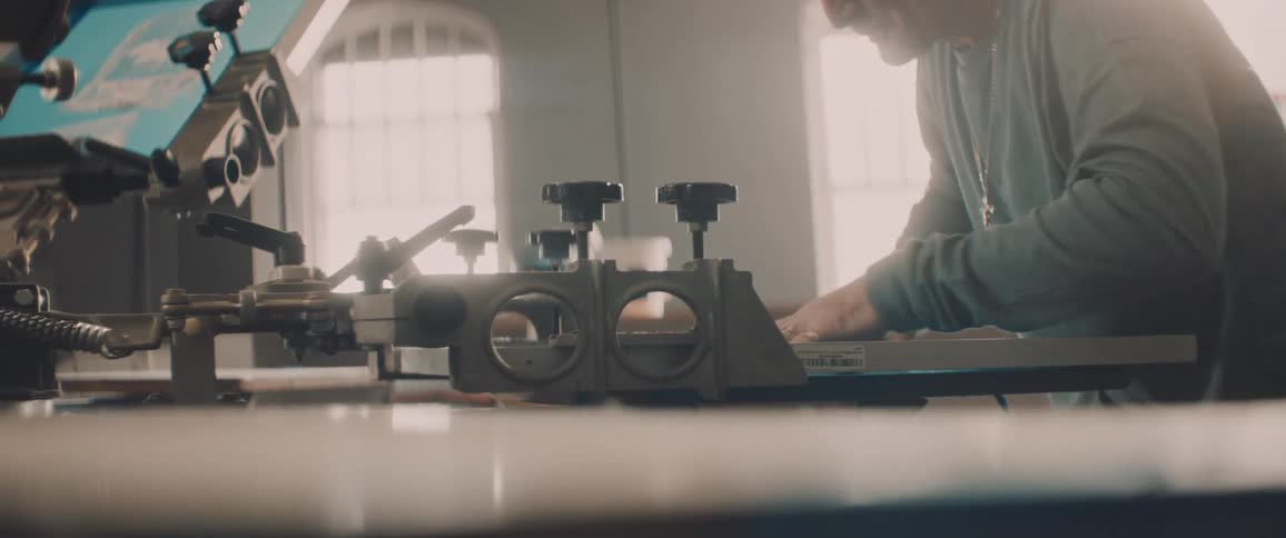 Man tightens knob and silk screens in workshop