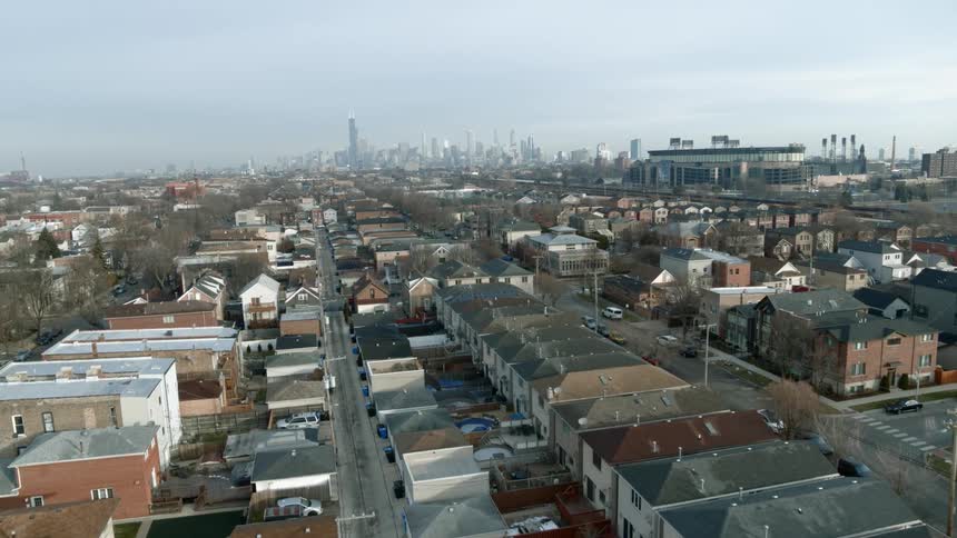 A car drives past the homes before the city