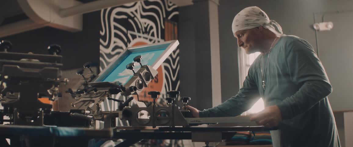 A man is putting a graphic on a shirt