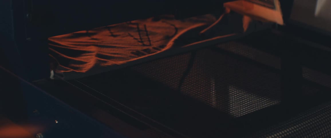 Printed graphic t shirt passes under light in machine