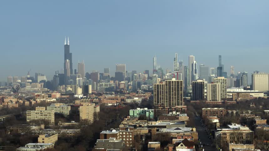 Neighborhood buildings and streets lead to a city skyline