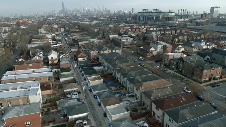Low lying residential buildings stretch toward foggy city skyline