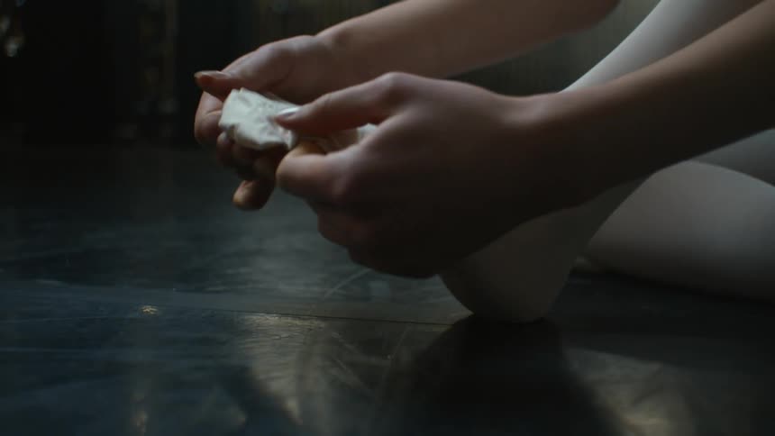 Female ballet puts on white tights