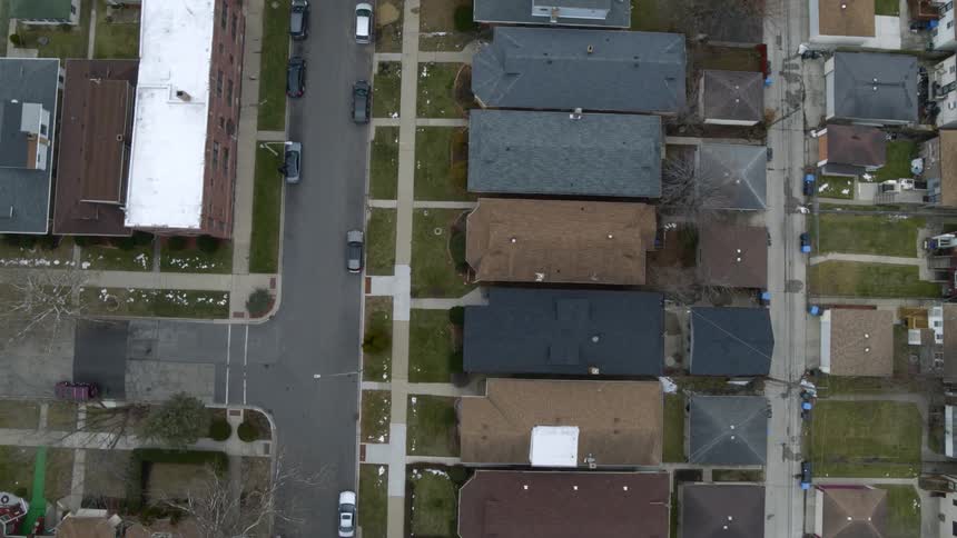 An aerial view of houses and cars in a neighborhood
