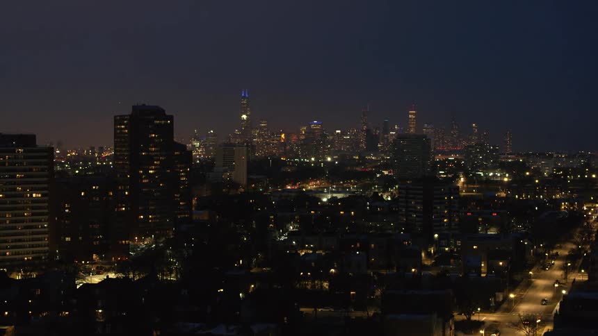 A big city with tall skyscrapers and lights on at night