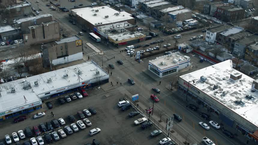 Aerial view of cars driving on the street of a smal town at winter