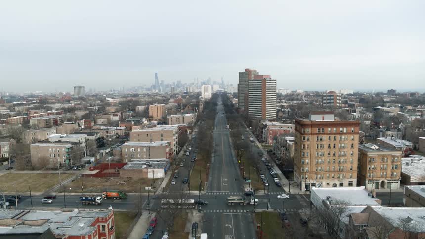 Traffic travels through a large intersection in a city on a cloudy day