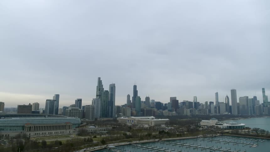 Aerial view of the skyscrapers on the city skyline next to a marina at sunset