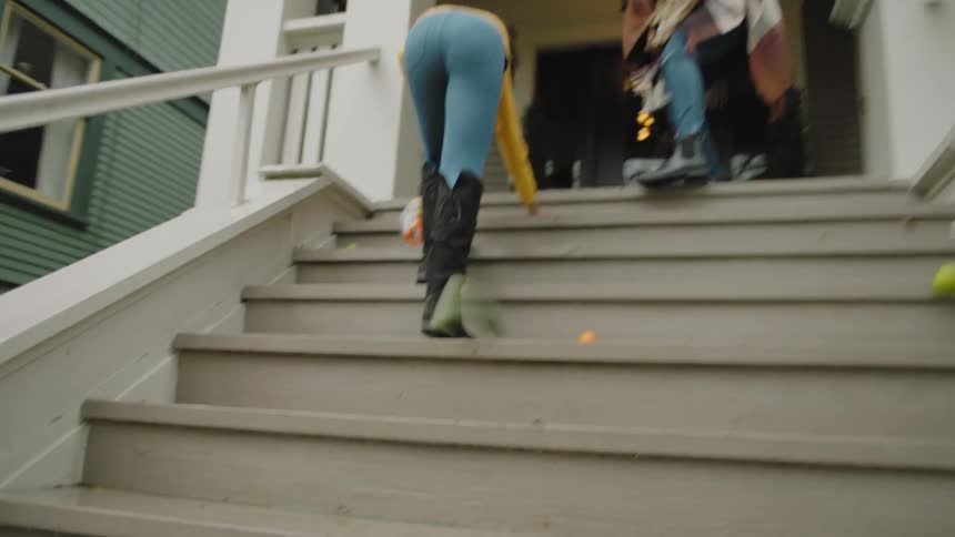 A woman and her daughter scramble to pick up groceries that have fallen from the bottom of a paper grocery bag