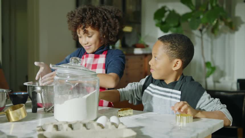 Family playing with food while cooking at home