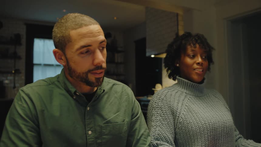 A man and woman talk together at home