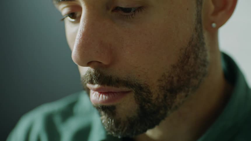 Close up of the face of a bearded young man with an earring