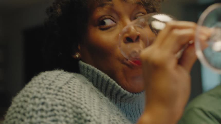A woman drinks some of her red wine