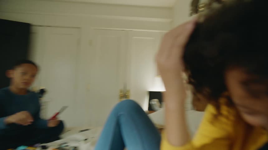 Two children are playing on a bed with lego blocks during the day
