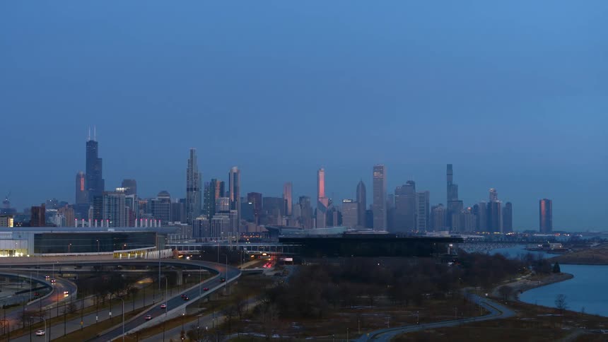 Vehicles travel towards the city with tall buildings