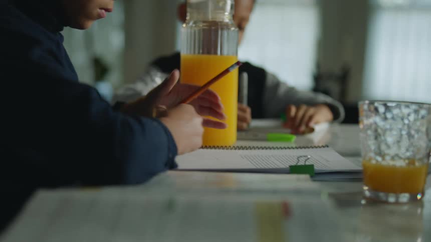 A child pouring juice onto a piece of paper