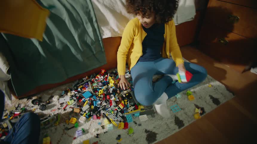 A boy dumps toys all over the floor to play