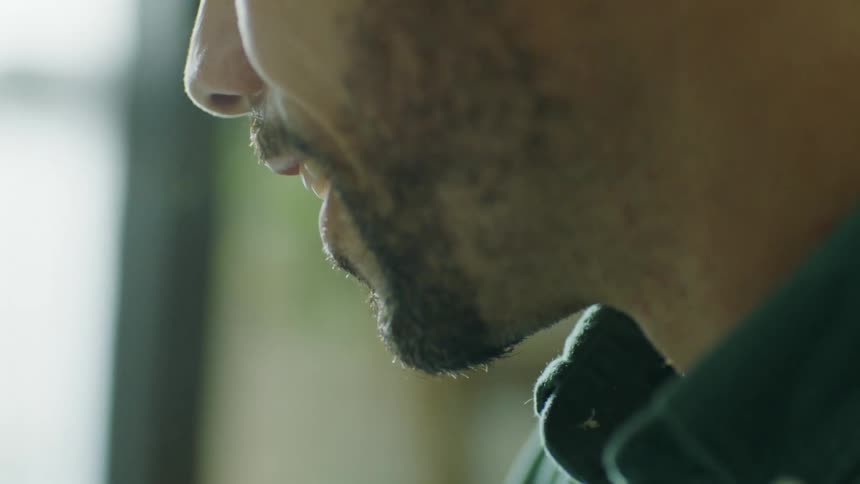 A man is writing notes as he looks at a laptop