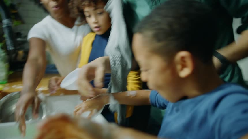 Family plays while washing dishes